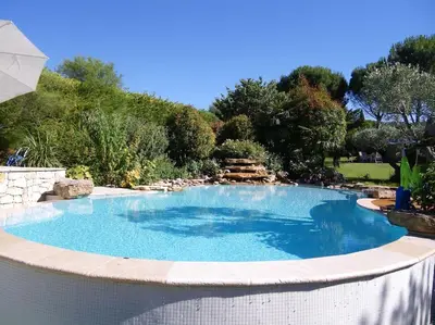 a large swimming pool in a yard with a stone perimeter at Maison de Charme au Pays de Cézanne in Aix-en-Provence