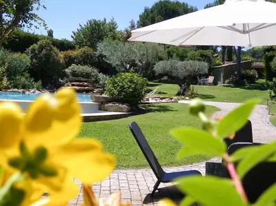 a white umbrella and a chair next to a pool at Maison de Charme au Pays de Cézanne in Aix-en-Provence