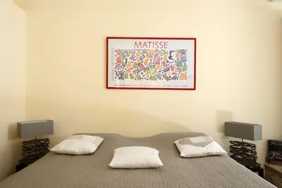 a bedroom with a bed with a picture on the wall at Maison de Charme au Pays de Cézanne in Aix-en-Provence