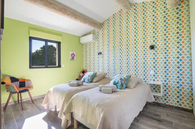 a bedroom with two beds in a room with yellow walls at Maison contemporaine - grand jardin et piscine privée in LʼIsle-sur-la-Sorgue