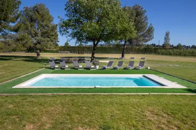 a swimming pool with lounge chairs and a swimming pool at Maison contemporaine - grand jardin et piscine privée in LʼIsle-sur-la-Sorgue