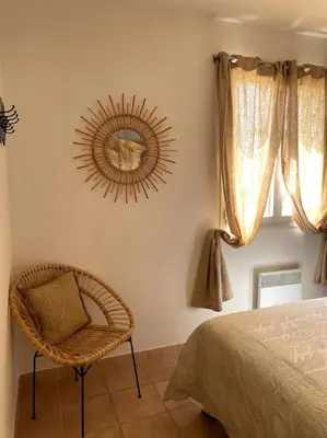 a bedroom with a chair and a mirror on the wall at Une Oasis au Pays de Cézanne in Aix-en-Provence