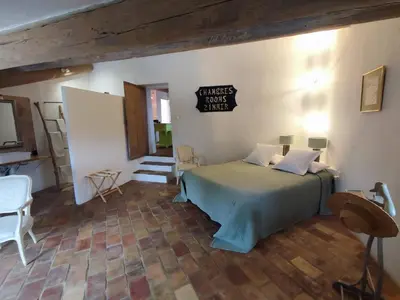 a bedroom with a bed and a sign on the wall at Le Mas Réséda in Goult