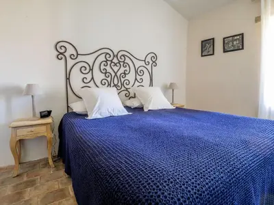 a bedroom with a large bed with a blue comforter at Le Mas Réséda in Goult