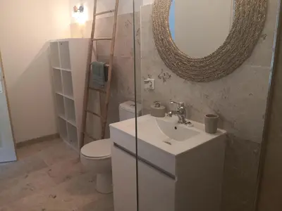 a bathroom with a sink and a toilet and a mirror at Le Mas Paolo in Le Thor