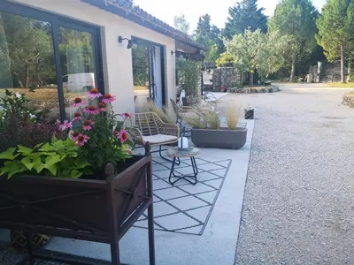 a patio with potted plants and a table and chairs at Le Mas Paolo in Le Thor