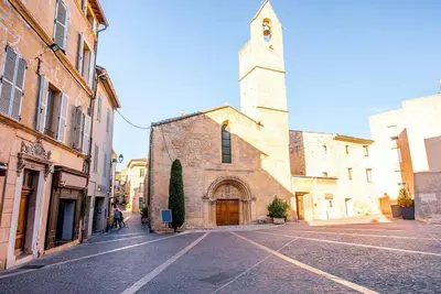 an old stone church with a steeple on a street at La Suite TAMAN au centre de Salon in Salon-de-Provence