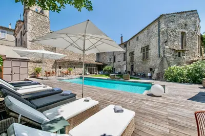 an outdoor pool with lounge chairs and an umbrella at La Chapelle sur la Sorgue in LʼIsle-sur-la-Sorgue