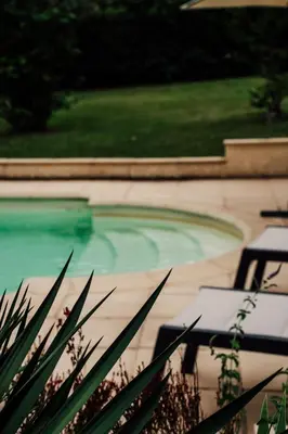 a swimming pool with two benches in front of it at Maison des lavandes in Saint-Cannat