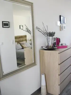 a mirror on a wall next to a dresser at Studio à Deux Pas d'Aix in Aix-en-Provence