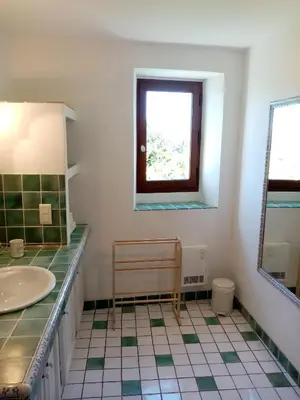 a bathroom with a sink and a window and a mirror at Le Lavoir in Lacoste