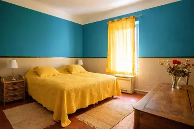 a bedroom with blue walls and a bed with a yellow blanket at Maison en campagne avec vues panoramiques - close to a lake in La Tour-dʼAigues