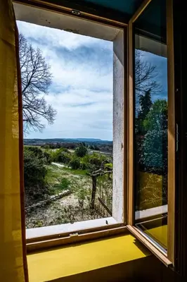 an open window with a view of a field at Maison en campagne avec vues panoramiques - close to a lake in La Tour-dʼAigues