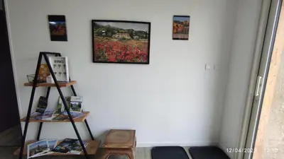 a room with a white wall with pictures on the wall at Une escapade en Luberon in Bonnieux