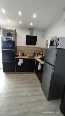 a kitchen with a black refrigerator and a stove at Une escapade en Luberon in Bonnieux
