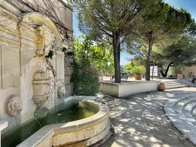 a fountain in the courtyard of a building at Maison de Vacances en Provence avec Piscine, Golf à Proximité, Fibre et Linge Haut de Gamme - FR-1-658-9 in Mallemort