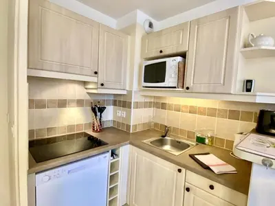a kitchen with white cabinets and a sink and a microwave at Maison de Vacances en Provence avec Piscine, Golf à Proximité, Fibre et Linge Haut de Gamme - FR-1-658-9 in Mallemort