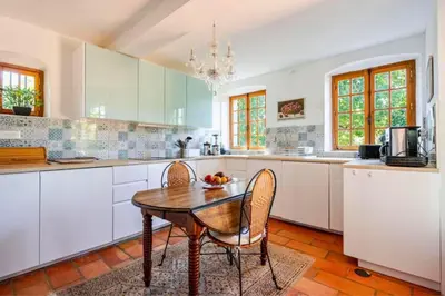 a kitchen with a wooden table and two chairs at Joli mas 