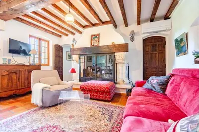 a living room with a red couch and a fireplace at Joli mas 