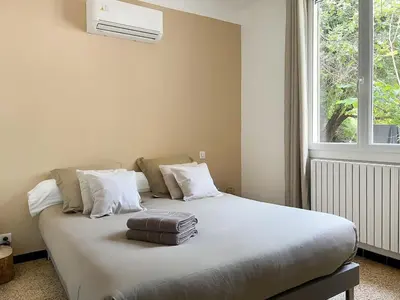 a bedroom with a bed with a suitcase on it at La Bohème à Lacoste in Lacoste