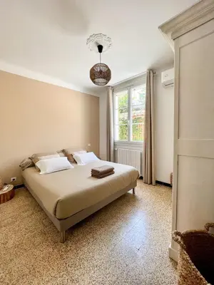 a bedroom with a bed and a window at La Bohème à Lacoste in Lacoste