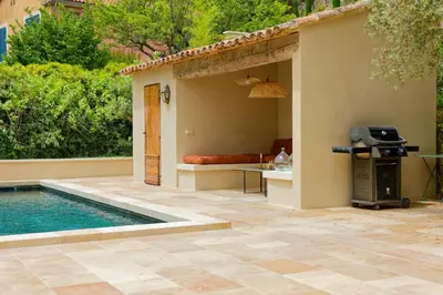 a patio with a pool and a grill next to a house at La Bohème à Lacoste in Lacoste