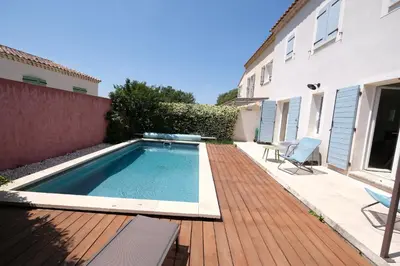 a swimming pool on a wooden deck next to a house at nice house with private pool - 6 persons in the center of the village of mérindol in the luberon in provence in Mérindol