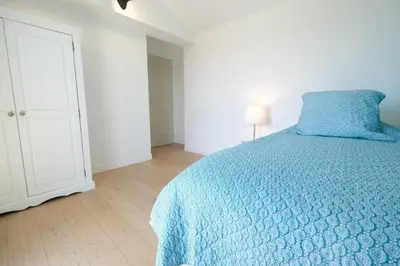 a bedroom with a blue bed and a white cabinet at nice house with private pool - 6 persons in the center of the village of mérindol in the luberon in provence in Mérindol