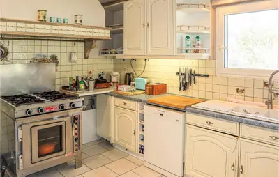 a kitchen with white cabinets and a stove top oven at Gorgeous Home In Vernègues in Vernègues