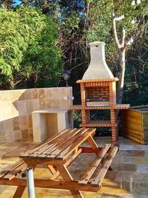 a wooden bench and a bird house on a patio at Appartement charmant à Avignon, 45 m² avec piscine partagée in Avignon