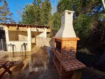 a brick fireplace on a patio with a table at Appartement charmant à Avignon, 45 m² avec piscine partagée in Avignon