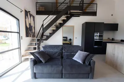 a living room with a couch and a staircase at Maison Réglisse du MAS LOU CAPY in Salon-de-Provence