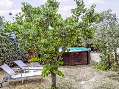 a tree and a chair next to a swimming pool at Holiday Home La Campagne des Ocres by Interhome in Rustrel