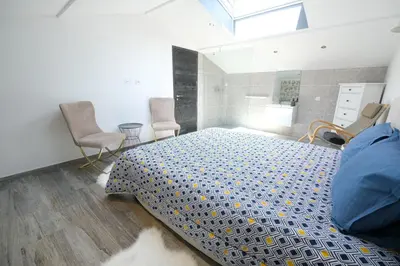 a bedroom with a bed and two chairs in it at charming villa with heated pool, 14 people, located in aureille, near les baux de provence, in the alpilles in Aureille
