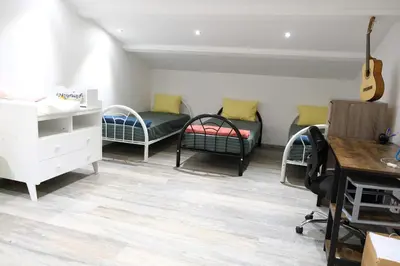 a room with two beds and a desk and a guitar at charming villa with heated pool, 14 people, located in aureille, near les baux de provence, in the alpilles in Aureille