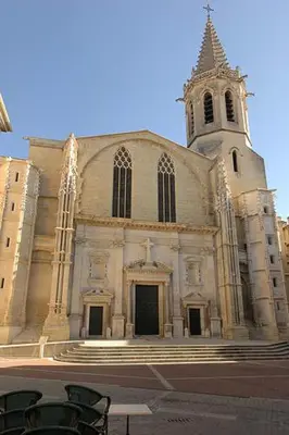 a large church with a tower and a steeple at Appartement climatisé avec cour en centre ville in Carpentras