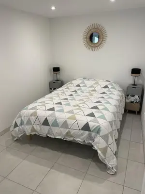 a bedroom with a bed and a mirror on the wall at Appartement climatisé avec cour en centre ville in Carpentras