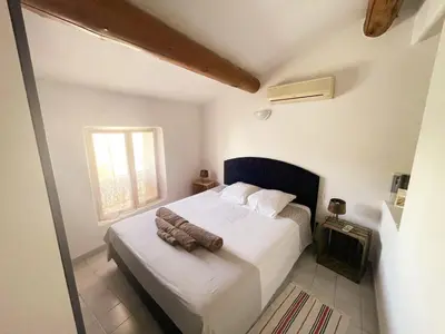 a bedroom with a bed and a window at Lumineux Duplex au coeur de l'Isle in LʼIsle-sur-la-Sorgue