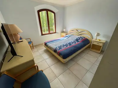 a bedroom with a bed and a table and a window at BASTIDE DU DEFENDS in Pertuis