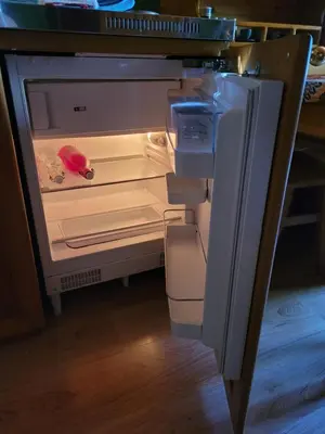 an empty refrigerator with its door open in a kitchen at La Roulotte des Oliviers in Saint-Pierre-de-Vassols
