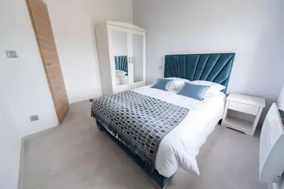 a bedroom with a large bed with a blue headboard at MAISON LAVANDE du MAS LOU CAPY in Salon-de-Provence