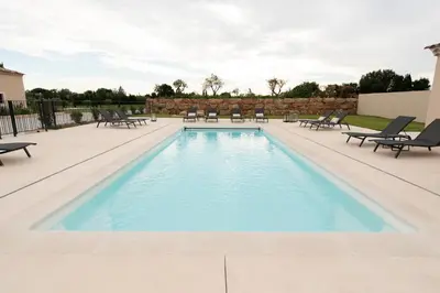 a pool with chaise lounge chairs and a patio at MAISON LAVANDE du MAS LOU CAPY in Salon-de-Provence