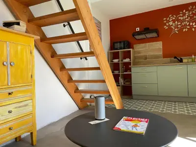 a kitchen with a table and a spiral staircase at MAS-Calou in Coustellet
