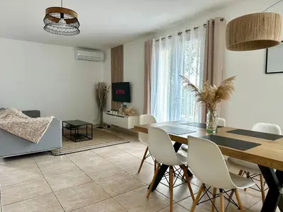 a dining room with a table and white chairs at Une maison en Provence in Pierrevert