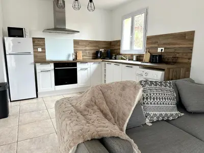 a living room with a couch and a kitchen at Une maison en Provence in Pierrevert