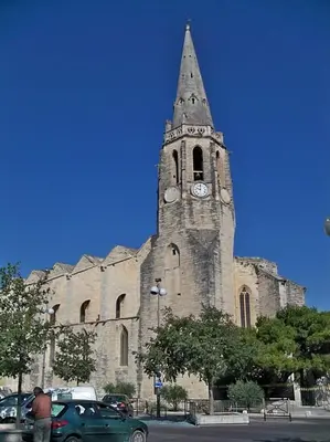 a church with a tower with a clock on it at Maison paisible et ensoleillée in Avignon