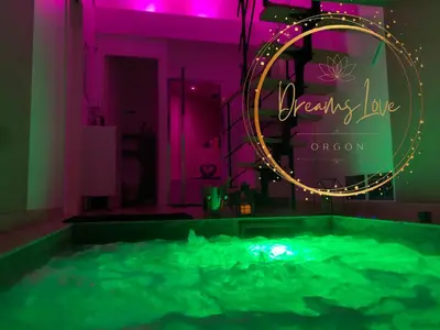 a hot tub in a room with a neon sign at Appartement Love room avec jacuzzi et hammam privatisé Lieu insolite en amoureux Spa détente assurée avec de doux massages en options sur demande in Orgon