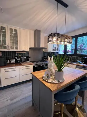 a kitchen with white cabinets and a wooden counter top at Maison idéale pour les familles avec piscine privée - Fontaine-de-Vaucluse in Fontaine-de-Vaucluse