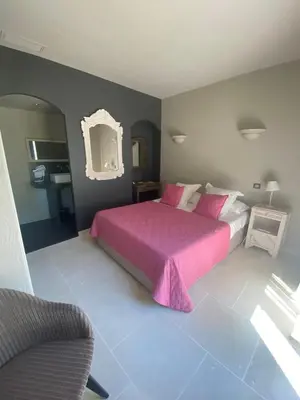 a bedroom with a pink bed and a chair at Property with panoramic views in Cabrières-dʼAvignon