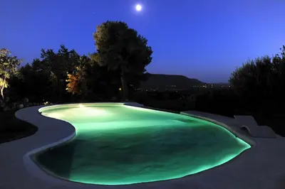 a large green swimming pool at night at Property with panoramic views in Cabrières-dʼAvignon